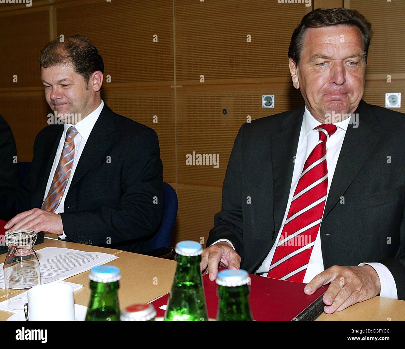 (Dpa) - German Chancellor Gerhard Schroeder (R) komprimiert seine Lippen in eine dünne Linie und Sozialdemokraten Generalsekretär Olaf Scholz macht das gleiche, vor einer Partei Führer treffen in Berlin, 28. April 2003. Desperate Kickstart die angeschlagene deutsche Wirtschaft, Schröder hat vorgeschlagenen schneiden Arbeitslosengeld, Verringerung der Kündigungsschutz und Hieb Lohnnebenkosten. Linke mich Stockfoto