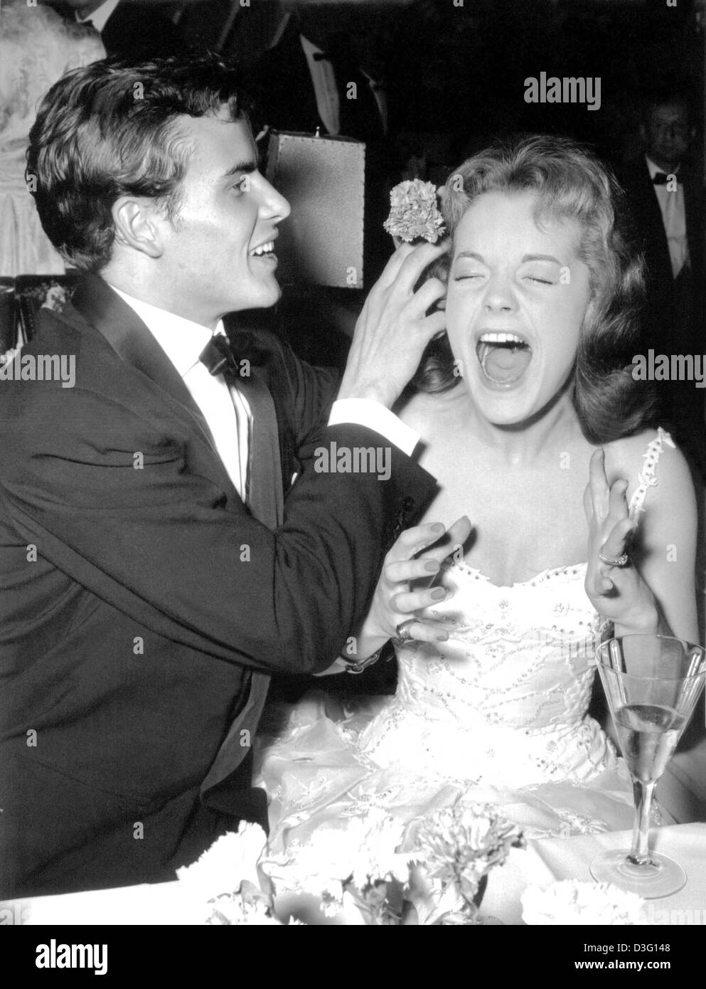 (Dpa-Dateien) - deutscher Schauspieler Horst "Hotte" Buchholz setzt eine Blume ins Haar von seiner Kollegin Romy Schneider während des Film-Ball in West-Berlin, 5. Januar 1957. Horst Buchholz starb 3. März 2003 im Alter von 69 in Berlin von einer "schweren Krankheit". Buchholz war einer der wenigen deutschen Schauspieler zu internationalem Ruhm zu kommen und in Hollywood erfolgreich zu sein. Geboren am 4. Dezember 1933 in Berlin, B Stockfoto