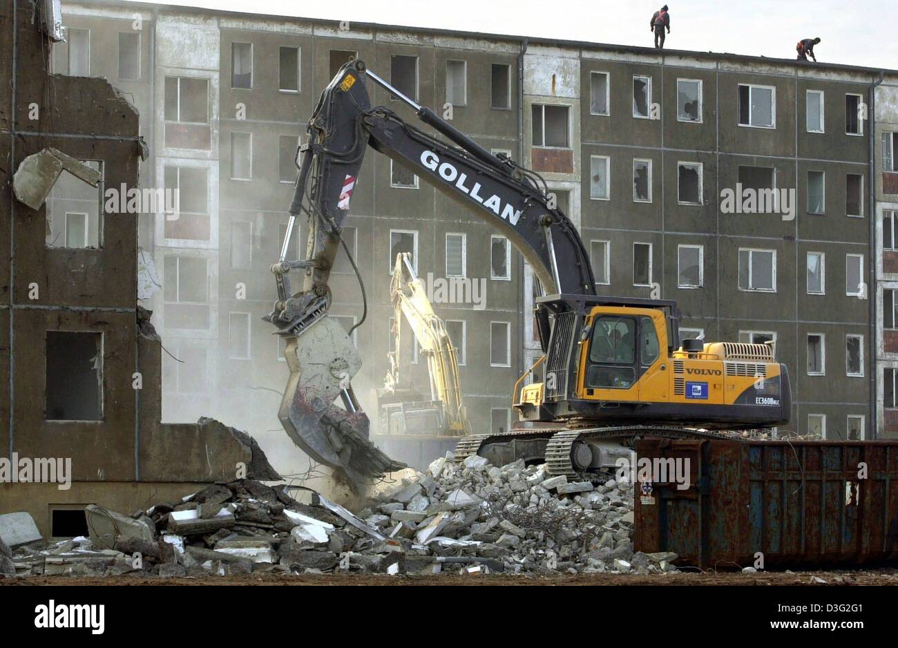 (Dpa) - ein Bagger der Gollan Recycling, ein Unternehmen für den Abriss arbeitet, reißt ein Hochhaus gebaut in den 70er Jahren in der ehemaligen DDR in Dranske, Deutschland, 6. März 2003. Die Wohnungen waren frei. Die Zahl der Einwohner in den letzten Jahren um 40 Prozent gesunken, und die Arbeitslosenquote in Dranske liegt knapp 30 Prozent. Stockfoto