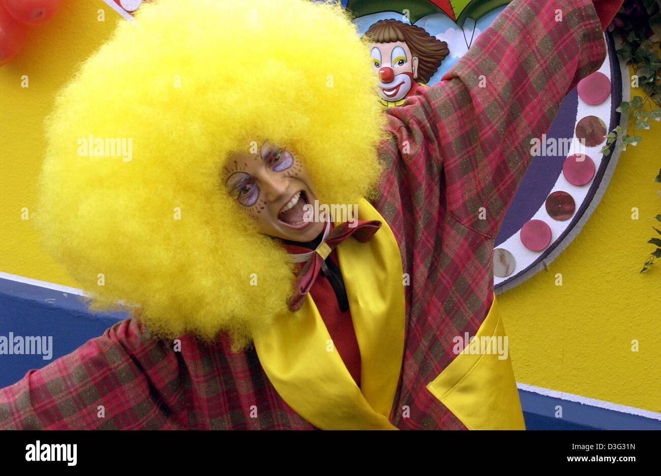 (Dpa) - deutsche Top-Model Heidi Klum trägt eine Karnevalskostüm mit einem gelben Perücke öffnet ihre Arme mit einem großen, offenen Lächeln in die Kamera während einer Karneval Prozession in Bergisch, Deutschland, 2. März 2003. Klum nahmen an den Karnevalszug in ihre Heimat Stadt Bergisch stattfand. An Karneval wird Montag (Rosenmontag) sie wieder einen Karneval beteiligen Stockfoto
