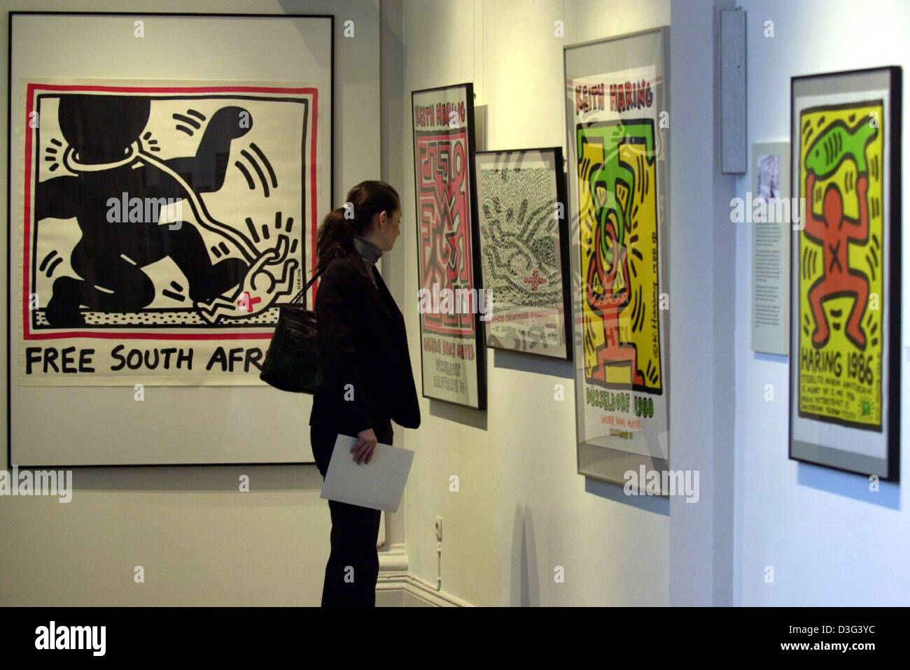 (Dpa) - eine Frau schaut Keith Haring Bilder in einem Museum Hamburg, 12. Februar 2003 ausgestellt. 85 Plakate und 30 Entwürfe für Bücher, Plastiktüten und andere Gegenstände sind vom 14 Februar bis zum 4. Mai 2003 gezeigt. Die Kunstwerke wurden zwischen 1982 und 1990 geschaffen. Haring, benutzte sie, um seine eigene Ausstellungen zu fördern oder seine politische Meinung zu äußern. Keith Haring wurde berühmt für seine sti Stockfoto