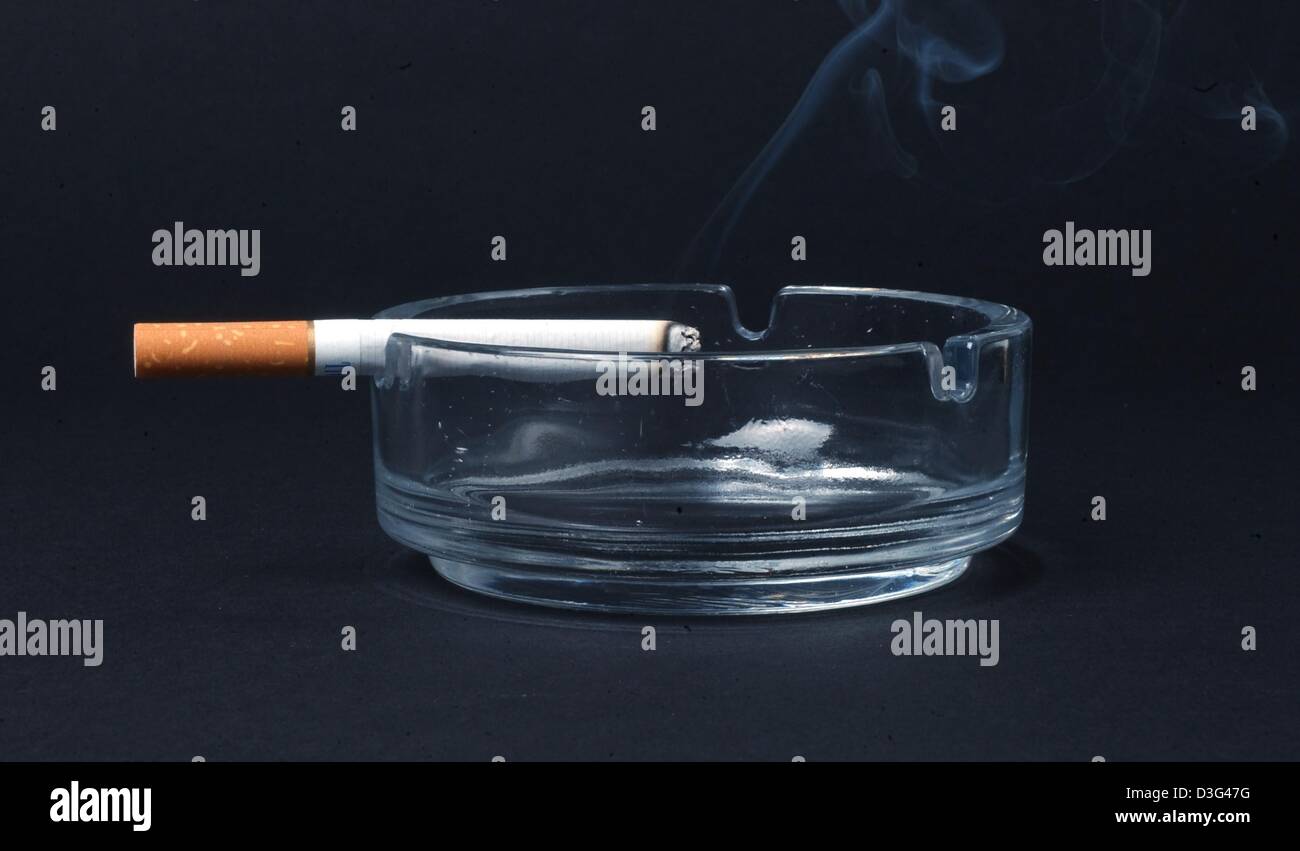 Dpa) - eine Zigarette glimmt am Rande der Aschenbecher in Berlin, 6.  Februar 2003. Deutsche sind immer noch der Rekordhalter in Rauchen in  Europa: nach Einschätzung von Experten etwa 6,8 Millionen Menschen