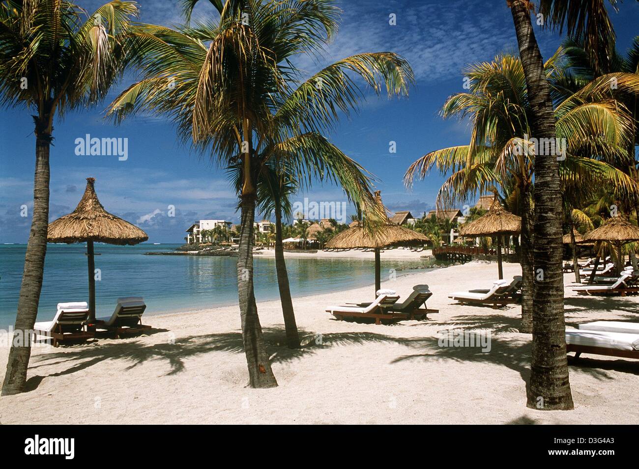 (Dpa) - Palmen und Sonnenschirmen stehen ordentlich auf den weißen Sandstrand des Luxushotels Sun International Le Touessrok auf der östlichen Küste von Mauritius, eine Insel im Indischen Ozean, 7. Dezember 2002. Das sechs-Sterne-Hotel wurde im Dezember 2002 nach Monaten Umbauzeit wiedereröffnet. Stockfoto