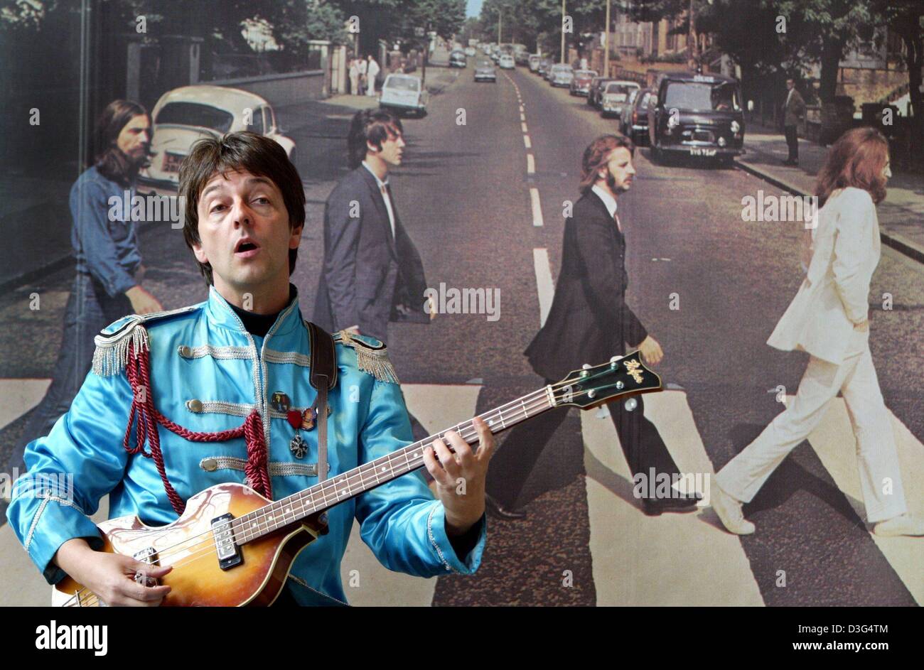 (Dpa) - Paul McCartney-Imitator Freddie kann spielt die Gitarre vor einem erweiterten Albumcover der Beatles in der Beatles-Ausstellung "Eine Legende Ohne Ende" (eine Legende ohne Ende) in Hannover, 12. Dezember 2003. Auf den Ausstellungen Besucher und Fans der legendären Band können schauen Sie sich eine Sammlung von Erinnerungsstücken wie Harrisons Gitarre, Ringo Starr " Stockfoto
