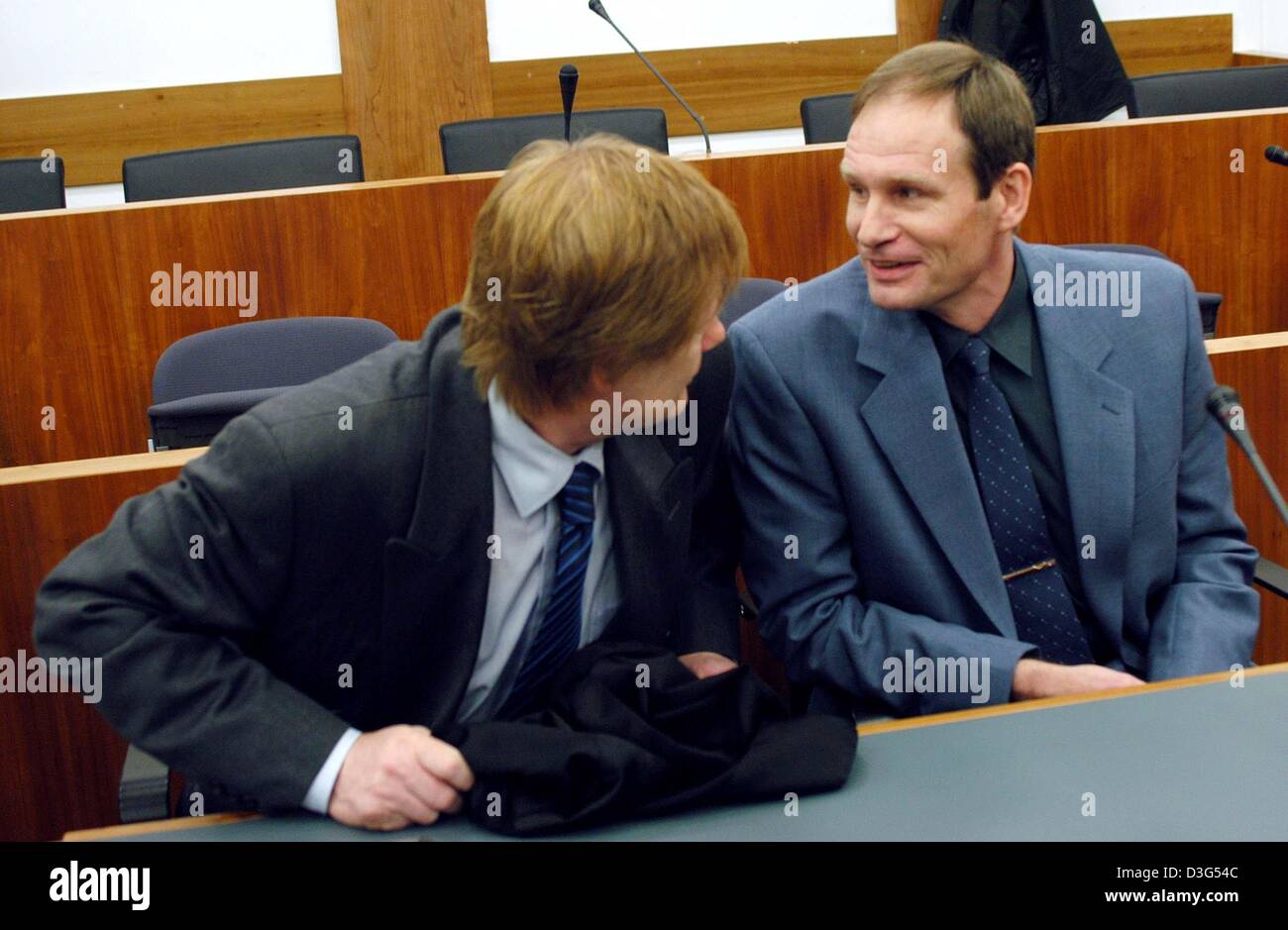 (Dpa) - chats 42 Jahre alte deutsche Computer-Spezialist Armin Meiwes (R) mit seinem Anwalt Harald Ermel am zweiten Tag seines Prozesses vor dem Amtsgericht in Kassel, Deutschland, 8. Dezember 2003. Das Gericht wurde eingerichtet, um Anzeigen von Videobändern, die zeigt, wie die selbsternannten Kannibalen getötet, zerschnitten und aß sein Opfer. Der zweite Tag der Mordprozess von Meiwes begann mit Beweis von gegeben werden Stockfoto