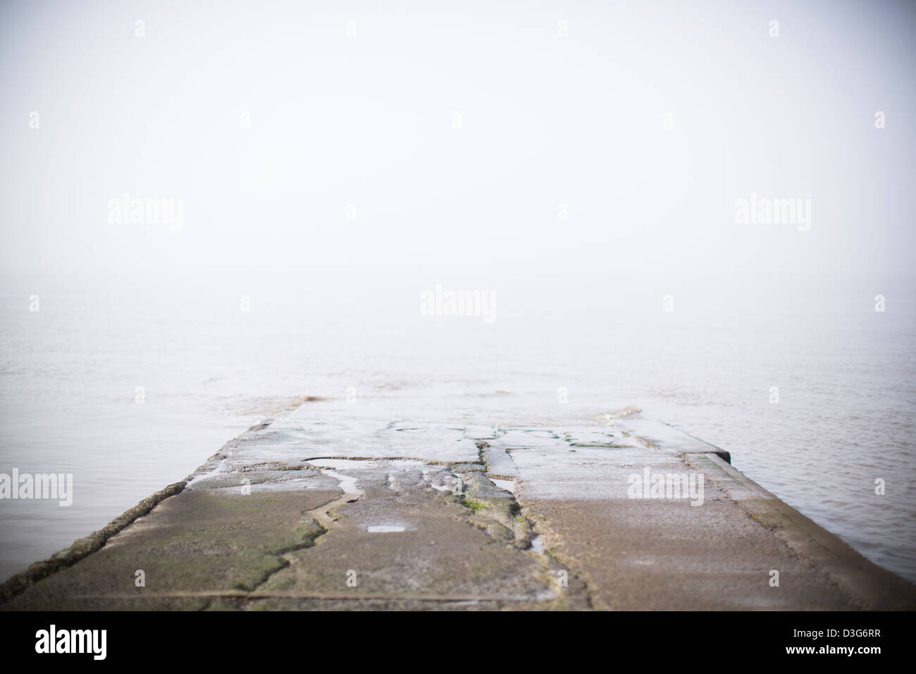 Beton-Slipanlage oder Gehweg Abstieg in das Meer auf die Küste von Clevedon, Somerset, UK in Nebel Meer oder Ozean Nebel gehüllt. Stockfoto