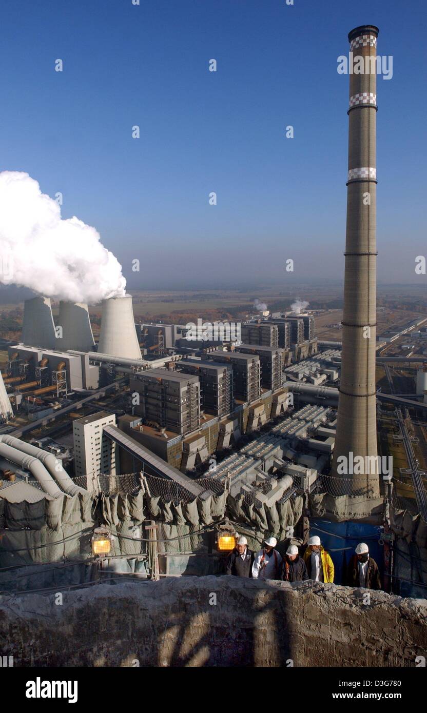 (Dpa) - stehen Arbeitnehmer am Rand des Schornsteins, die bereits bis zu einer Höhe von 150 Metern, im Braunkohle-Kraftwerk von Vattenfall Europe in Jaenschwalde, Deutschland, 12. November 2003 reduziert wurde. Der Schornstein, die früher 300 m hoch, soll abgerissen werden. Eine spezielle Abriss Maschine zermalmt den Stahlbeton, beginnend an der Spitze des Schornsteins. 30.000 Tonnen Stockfoto