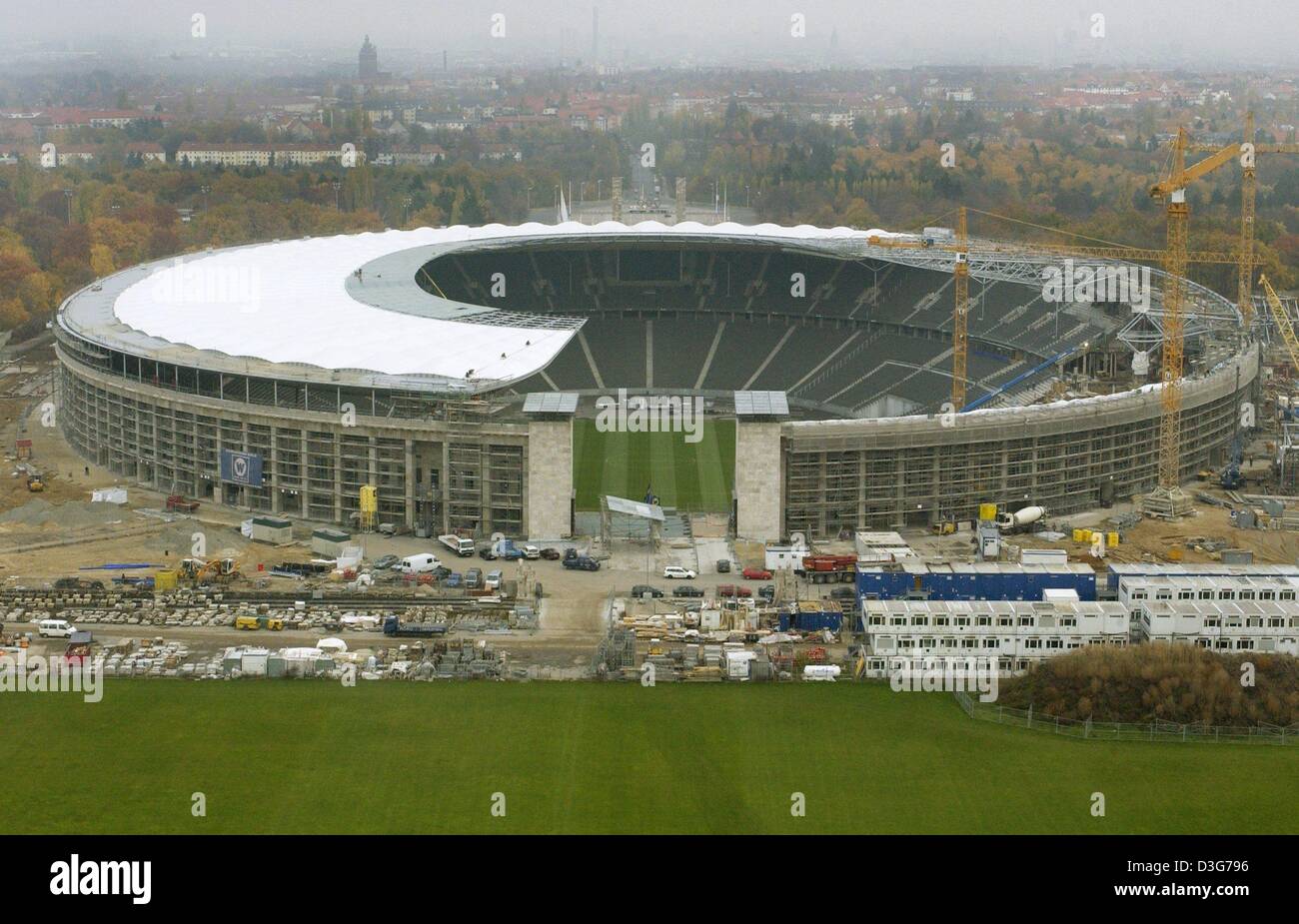 (Dpa) - ein Blick auf das Olympiastadion in Berlin, 7. November 2003. Das Stadion, das für die Olympischen Spiele in Berlin 1936 erbaut worden war, wird derzeit renoviert und ein Dach über den Grand-Ständen wird zur Vorbereitung des Stadions für die Fußball-WM in Deutschland 2006 hinzugefügt. Stockfoto