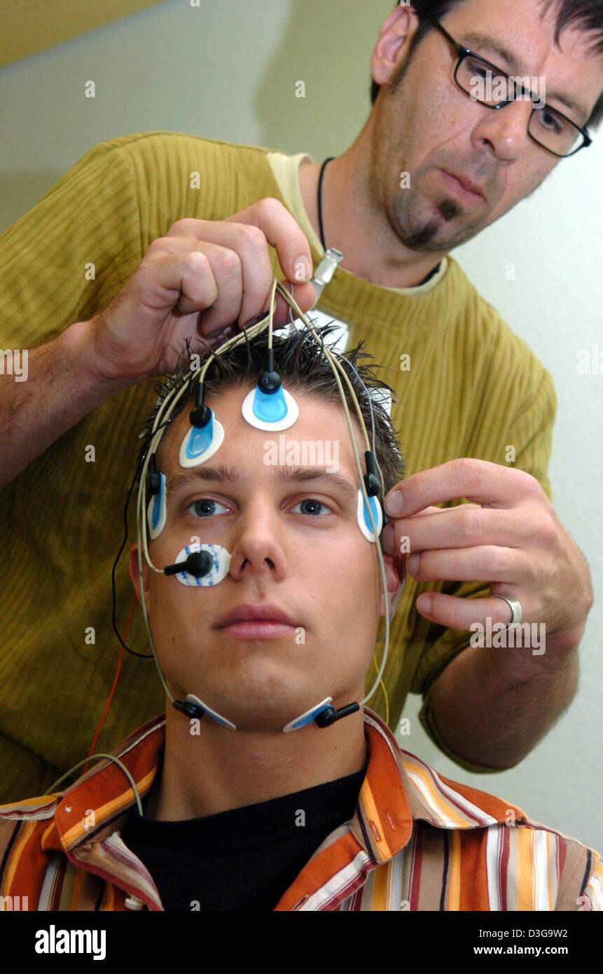 (Dpa) - ein Pfleger bringt Elektroden auf den Kopf des Patienten im Schlaflabor an der Universitätsklinik in Freiburg, Deutschland, 22. September 2004. Die Drähte übertragen der gemessenen Gehirnwellen auf eine Aufnahmemaschine. Im Moment über 300 Schlaf bestehen Labors untersuchen Sie verschiedene Arten von Schlafstörungen in Deutschland. Stockfoto
