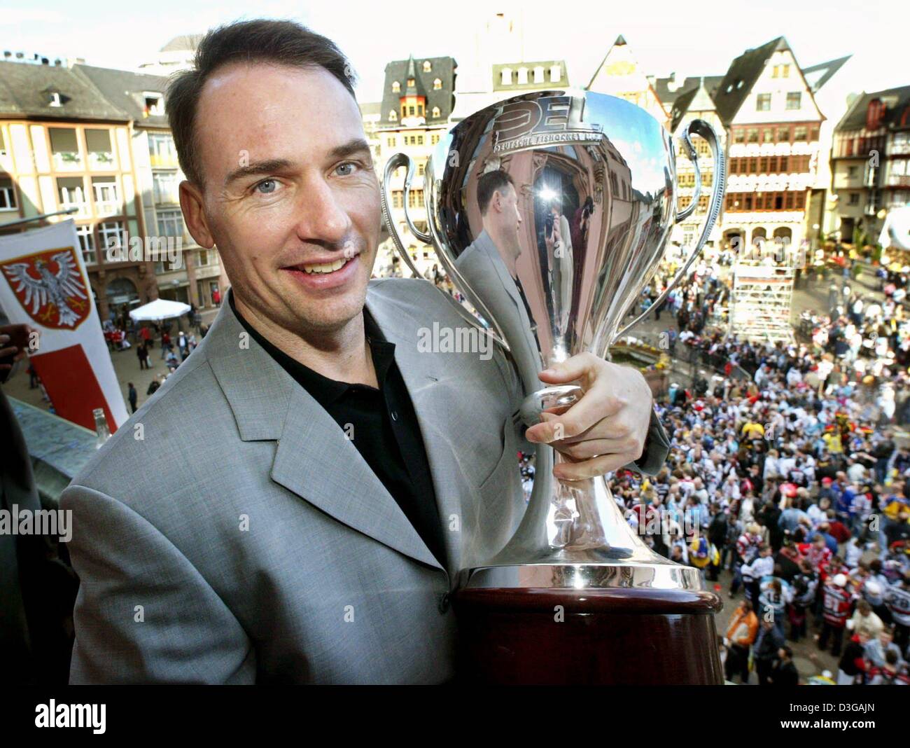 (Dpa) - Paul Stanton, der Kapitän der Frankfurt Lions-Eishockey-Mannschaft zeigt die deutsche Meisterschale auf dem Balkon des Römer Gebäude im Zentrum von Frankfurt am Main, 19. April 2004. Die Frankfurt Lions gewann der Deutsche Eishockey-Weltmeisterschaft am Freitag, 16. April, mit einem 4: 3-Sieg über die Berliner Eisbaeren. Stockfoto
