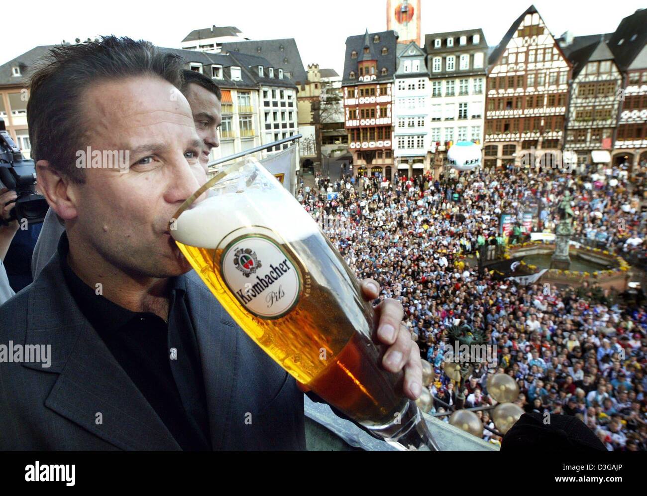 (Dpa) - Rich Chernomaz, Trainer der Frankfurt Lions-Eishockey-Team aus einem riesigen Glas Bier trinkt, wie das Team auf dem Balkon die Roemer Gebäude im Zentrum von Frankfurt am Main, 19. April 2004 gefeiert wird. Die Frankfurt Lions gewann der Deutsche Eishockey-Weltmeisterschaft am Freitag, 16. April, mit einem 4: 3-Sieg über die Berliner Eisbaeren. Stockfoto
