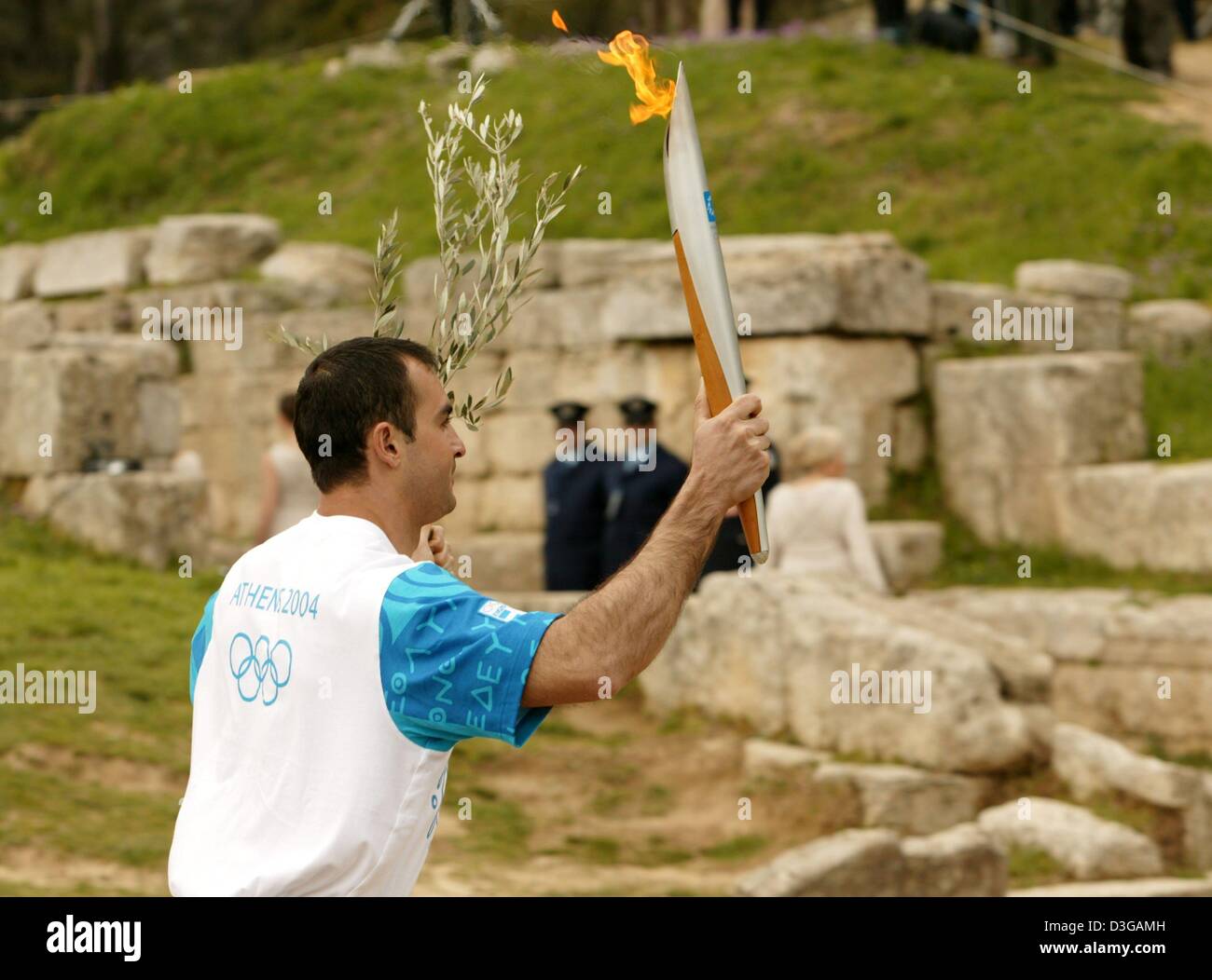 (Dpa) Griechische Speerwerfer Costas Gatsioudis trägt das Feuer während der Proben der Blitz-Zeremonie der Olympischen Flamme für Athen Olympischen Sommerspiele, vor dem Hera-Tempel im antiken Olympia auf Mittwoch, 24. März 2004. Stockfoto