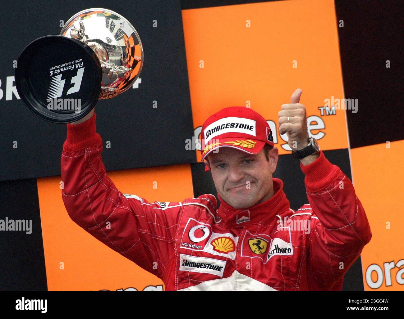 (Dpa) - brasilianischer Formel 1 pilot Rubens Barrichello (Ferrari) präsentiert stolz seine Trophäe nach dem dritten Platz in der brasilianischen Formel 1 Grand Prix auf der Rennstrecke Interlagos in der Nähe von Sao Paolo, Brasilien, 24. Oktober 2004. Stockfoto