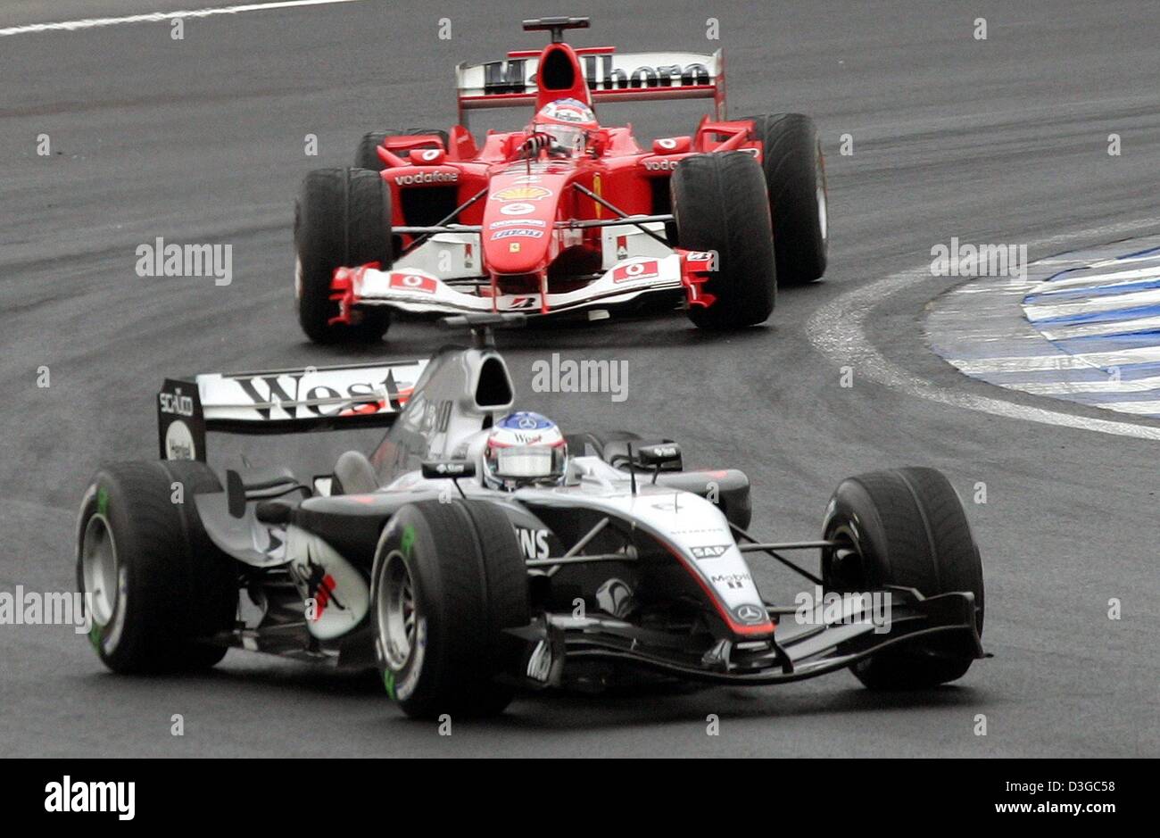 (Dpa) - finnische Formel-1-Pilot Kimi Raeikkoenen (vorne) von McLaren Mercedes ist gefolgt von brasilianischen Ferrari-Fahrer Rubens Barrichello in der brasilianischen Formel Eins Grand Prix auf der Rennstrecke Interlagos in Sao Paulo, Brasilien, 24. Oktober 2004. Stockfoto