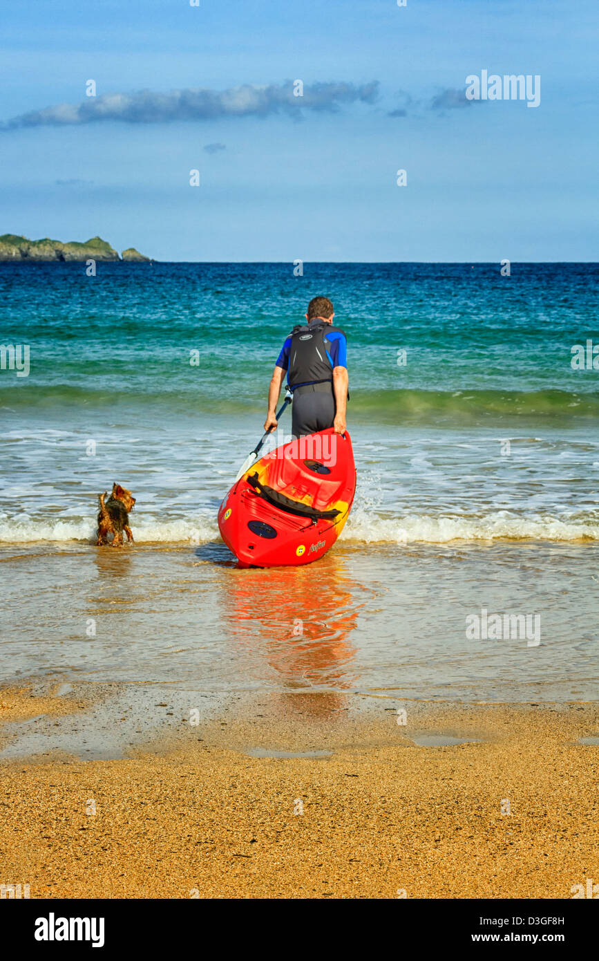Reifer Mann mit einem Kanu und Hund, Harlyn Bay, Cornwall, England Stockfoto