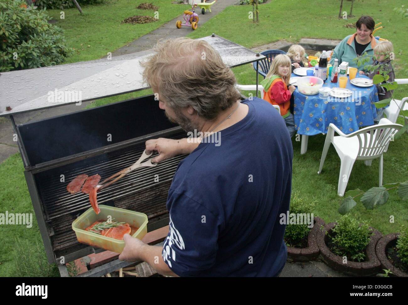 Dpa) - deutsche kitschiger in einem Schrebergarten: Uwe Martin Grill  Fleisch in seiner Familie Schrebergarten in Osnabrück, 31. August 2004. Die  fünfköpfige Familie besitzen einen 400 qm großen Garten an der Zuteilung