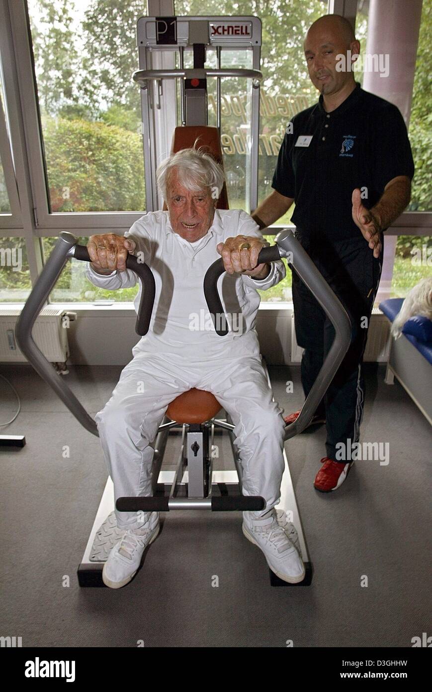 (Dpa) - niederländischer Schauspieler und Entertainer Johannes Heester (L) Übungen unter der Aufsicht von seinem Trainer Uli Epting an der "Medi-Sport" Gym in Starnberg, Deutschland, 17. August 2004. Heesters wird 100 Jahre und neun Monate alt und Besuche die Turnhalle zweimal in der Woche von oben Tp 45kg Gewichte zu heben. Heesters, der laut Guinness-Buch der Rekorde, der älteste aktive Schauspieler Alife, verwendet, um zu halten ist Stockfoto