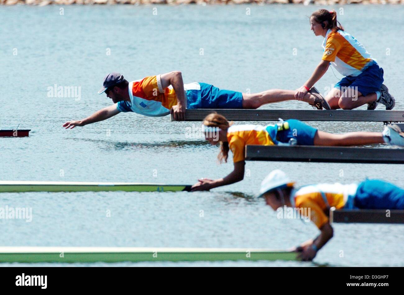 (Dpa) - Veranstaltungsort-Assistenten auf die Boote vor dem Start in die leichte Frauen einzelner Scull Hoffnungslauf Olympic Rowing Center in Shinias, Griechenland, 17. August 2004 halten. Stockfoto