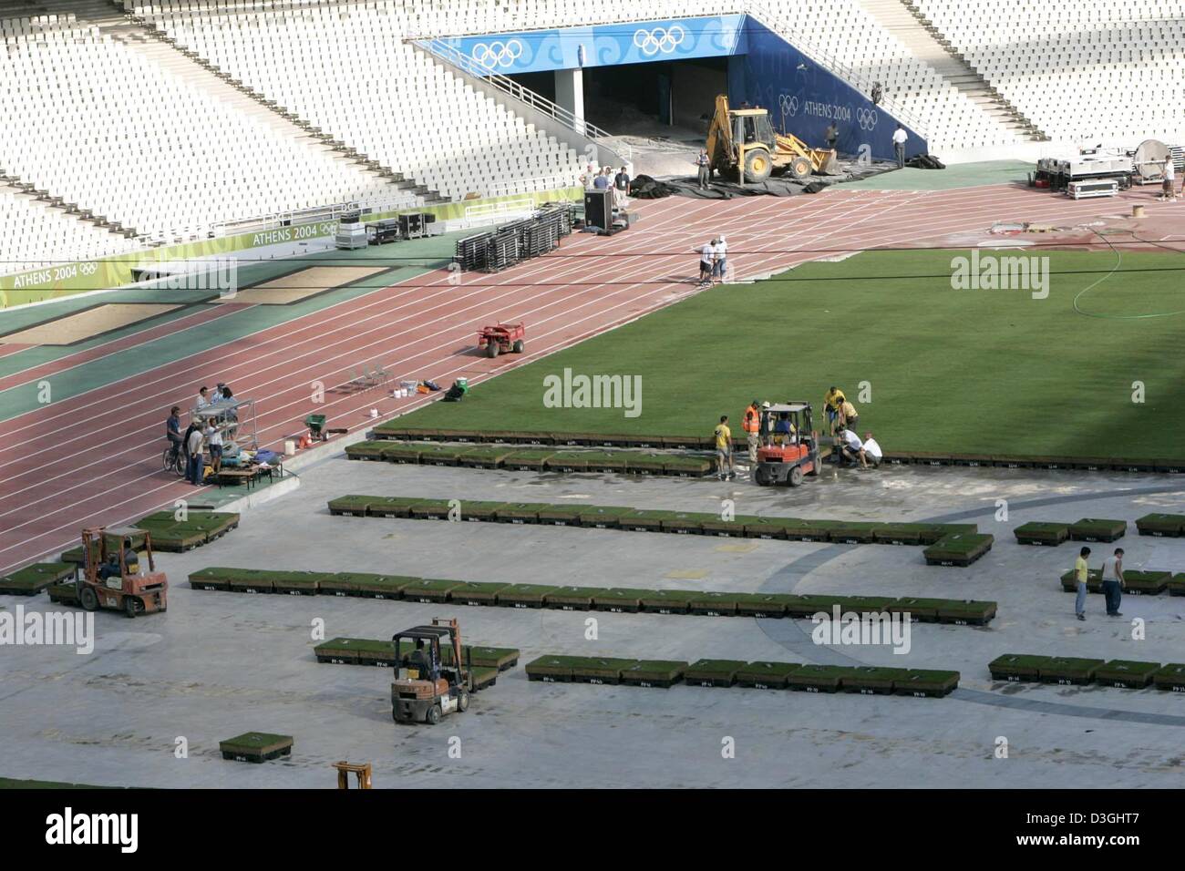 (Dpa) - Bodenpersonal installieren Abschnitte Gras auf dem Feld das Olympiastadion in Athen, Griechenland, 16. August 2004.  Die Leichtathletik-Veranstaltungen der Olympischen Spiele 2004 in Athen beginnen am Freitag, 20. August 2004. Stockfoto