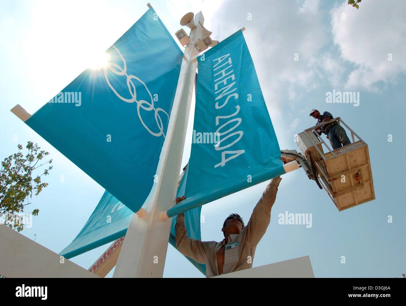(Dpa) - Bauherren anpassen Fahnen die diesjährigen Olympia-Logo im OAKA Olympic Complex in Athen, Griechenland, 10. August 2004 anzeigen.  Die Olympischen Spiele 2004 werden mit der Eröffnungsfeier am 13 August gestartet werden. Stockfoto