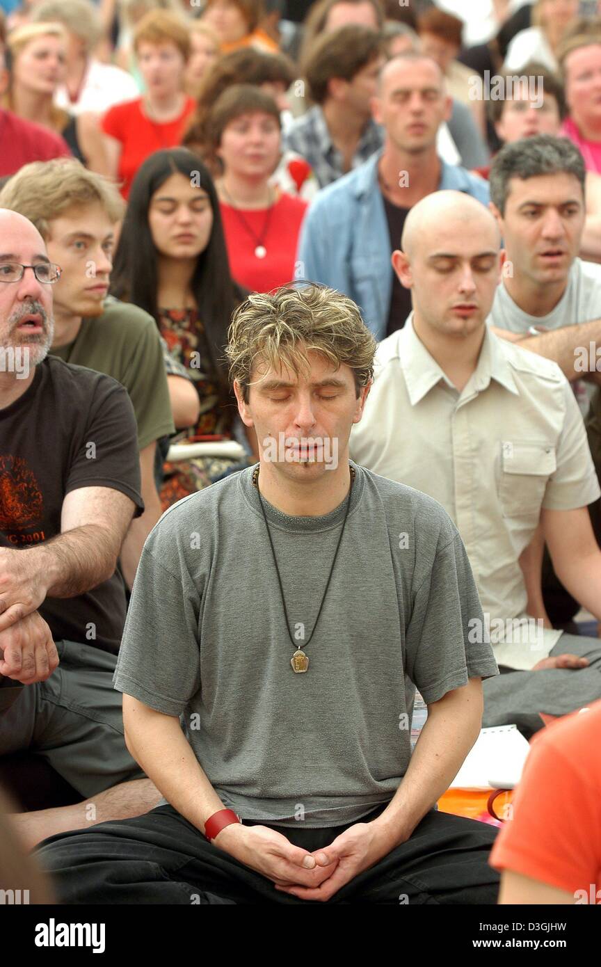 (Dpa) - Buddhisten meditieren, während der Eröffnungszeremonie ein buddhistisches Sommercamp in Immenhausen, Deutschland, Donnerstag, 29. Juli 2004. Mehrere tausend Buddhisten nehmen an der Einweihung des Sommerlagers die führt und berät Besucher in die Grundlagen der meditativen Praxis und buddhistischen Lehren. Stockfoto