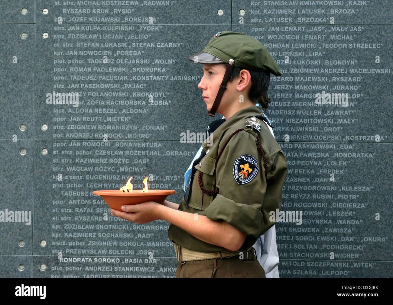 (Dpa) - ein kleiner Junge eine Schüssel mit Kerzen in seinen Händen hält er vor Denkmal stand der Widerstandskämpfer und Tote im Warschauer Aufstand in Warschau, Polen, 1. August 2004 erinnert. Stockfoto