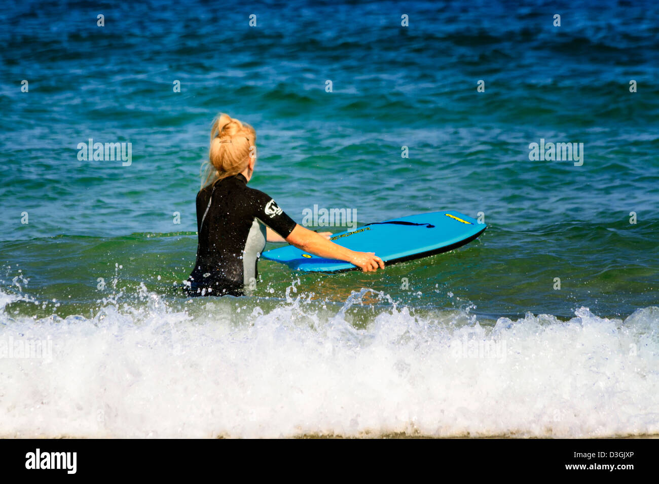 Reife Frau mit einem Surfen body Board, Harlyn Bay, Cornwall, England Stockfoto