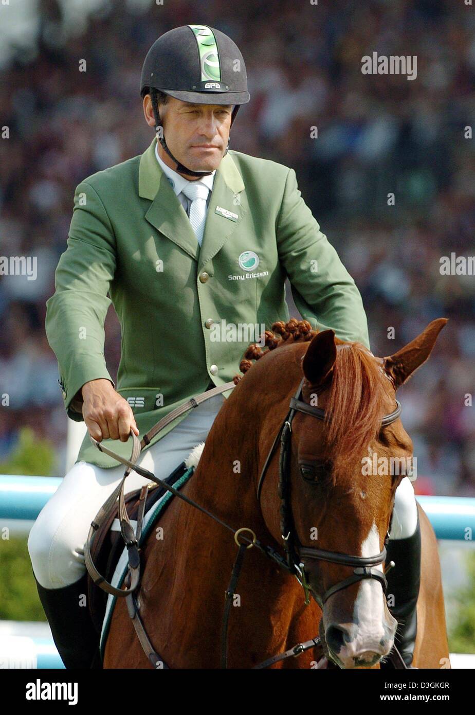 (Dpa) - Schweizer Markus Fuchs auf seinem Pferd "Tinka Boy" Fahrten während der Grand Prix von Aachen, Deutschland, 18. Juli 2004, Teil des CHIO (Concours Hippique International Officiel). Fuchs gewann den Grand Prix, welche insgesamt 255.646 Euro Preisgeld. Stockfoto