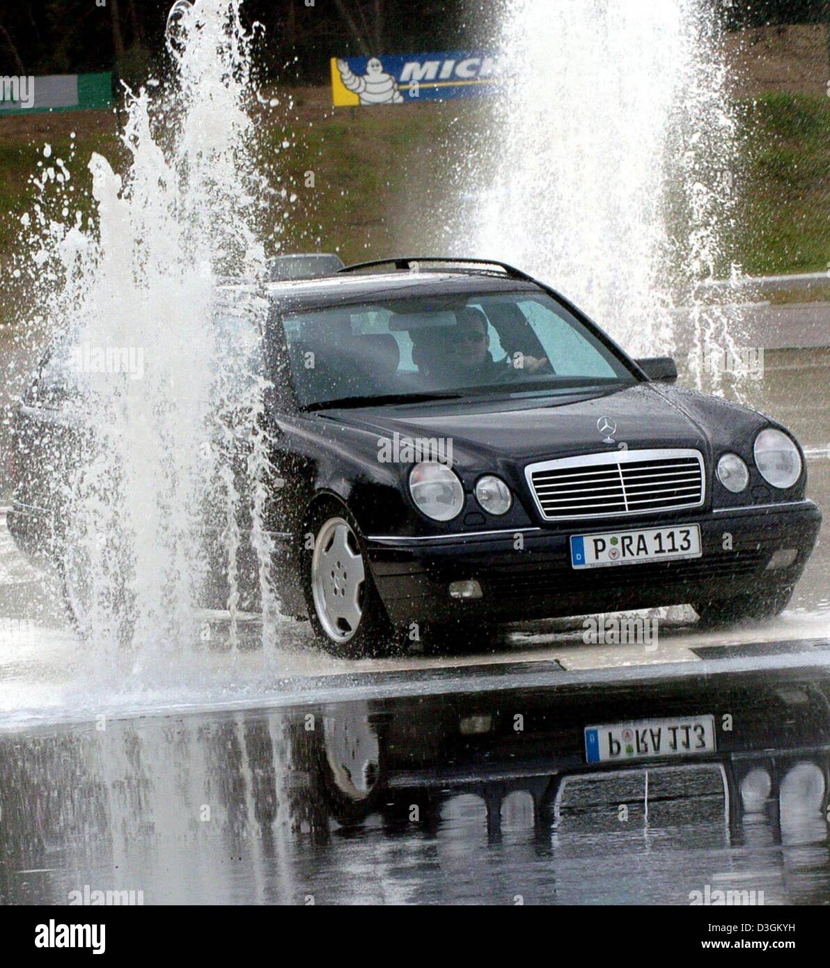 (Dpa) - ein Mitglied eine erweiterte treibende Klasse führt ein Mercedes Benz durch einen speziellen Wasser-Kurs auf dem ADAC (Deutsche Automobilclub) driving Center in Linthe, Deutschland, 27. Mai 2004. Gehört der Sonderklasse für Fahrer bringen das Auto bis zum Stillstand auf nassem Untergrund und trotzdem es durch zwei Brunnen führen. Stockfoto