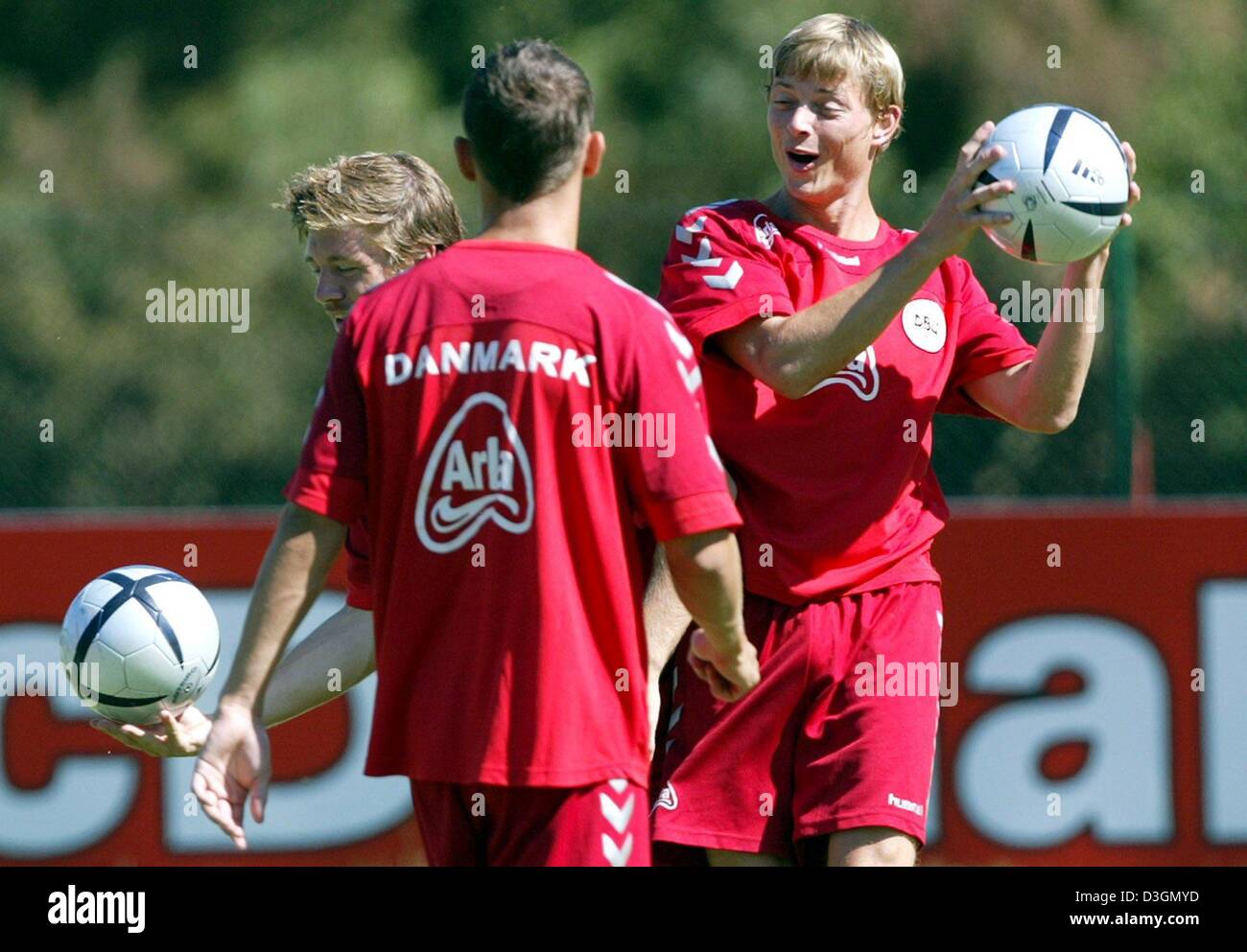 (Dpa) - leiten Sie Dänisch Jon Dahl Tomasson (R) lacht, wie er während einer Trainingseinheit von der dänischen Fußball-Nationalmannschaft in Alvor, Portugal, Freitag, 25. Juni 2004 einen Fußball in seinen Händen hält. Dänemark wird gegen die Tschechische Republik in das Endspiel der Fußball EM 2004 Quartal auf Sonntag, 27. Juni 2004 zu spielen. Stockfoto