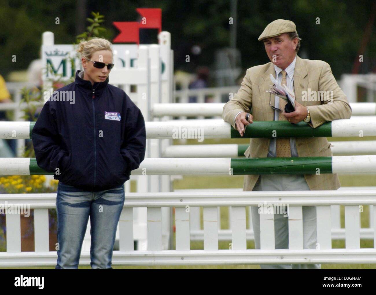 (Dpa) - British equestrian Zara Phillips (L), Enkelin der britischen Königin und Tochter von Prinzessin Anne, spricht mit ihrem Vater Mark Phillips über das Springreiten Kurs vor dem Start der Vielfalt Weltmeisterschaft im Springreiten in Luhmuehlen, Deutschland, 20. Juni 2004. Phillips hat siebten Platz im Wettbewerb. Stockfoto