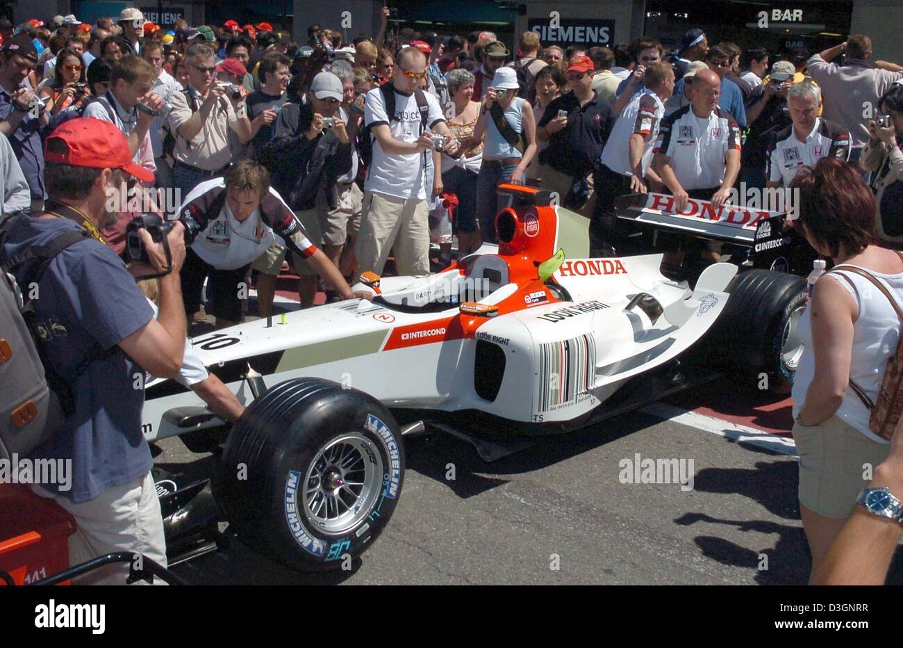 (Dpa) - Zuschauer untersuchen einen BAR-Honda Formel 1 Rennwagen während geschoben zurück in Richtung der Grube auf die Formel 1 Rennstrecke in Montreal, Kanada, 10. Juni 2004. Der Grand Prix von Kanada wird am Sonntag, 13. Juni 2004 stattfinden. Die kanadischen Yellow Press berichtete, dass Honda eine neue verwenden würde fast 1 000HP starke "wonder Motor" für den Grand Prix. Stockfoto