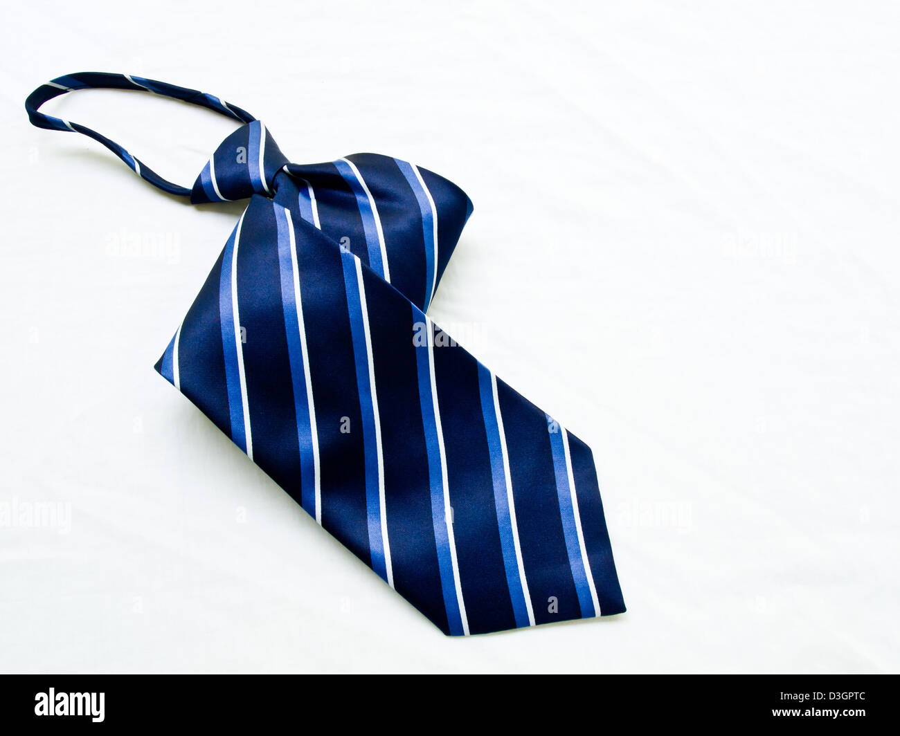 A aufgerollt gestreift blau-weiße Krawatte isoliert auf weißem Hintergrund. Stockfoto
