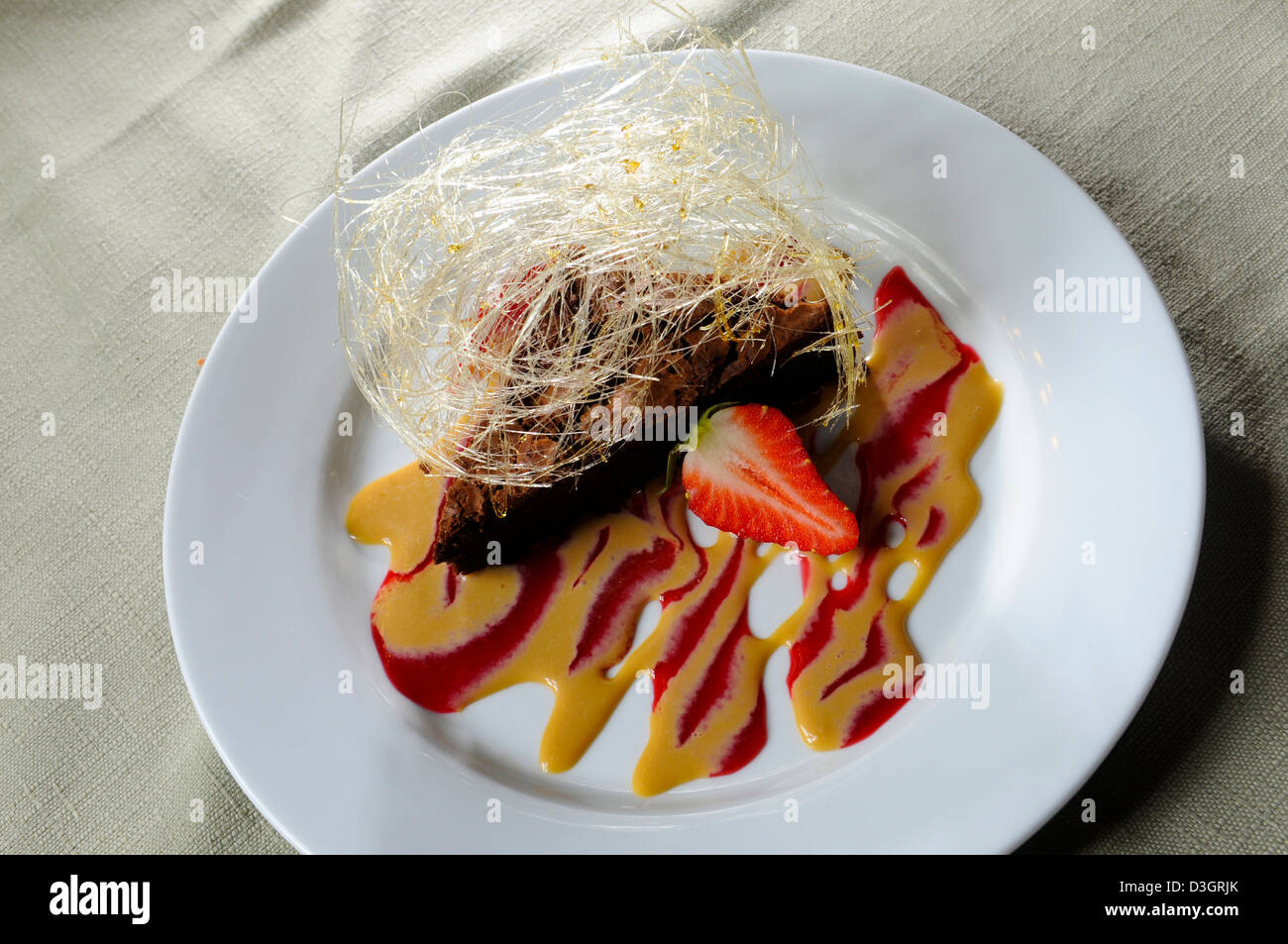 Reiche Schokoladenmousse Kuchen mit Baileys Sauce und gesponnenem Zucker in einem Shropshire-restaurant Stockfoto