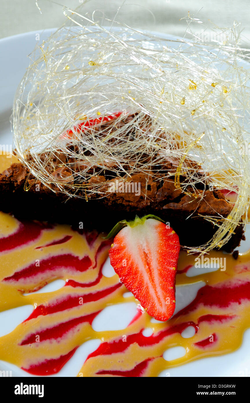 Reiche Schokoladenmousse Kuchen mit Baileys Sauce und gesponnenem Zucker in einem Shropshire-restaurant Stockfoto