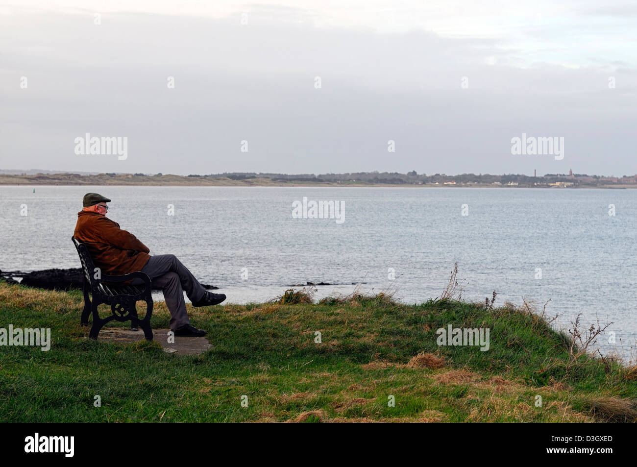 allein auf eigenen Sit Bank Blick auf Meer Ozean sitzen alte älterer Mann einsamer Single denken betrachten in Erinnerungen schwelgen Abends Sonnenuntergang Winter Stockfoto