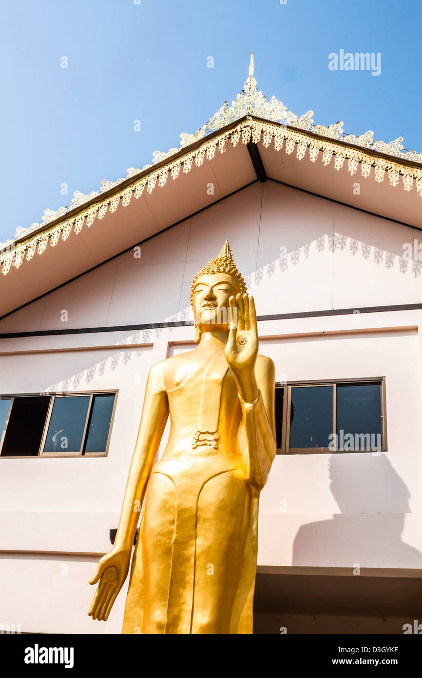 Stehende bronzene Buddhastatue Bild vor Mönch Schulgebäude Stockfoto