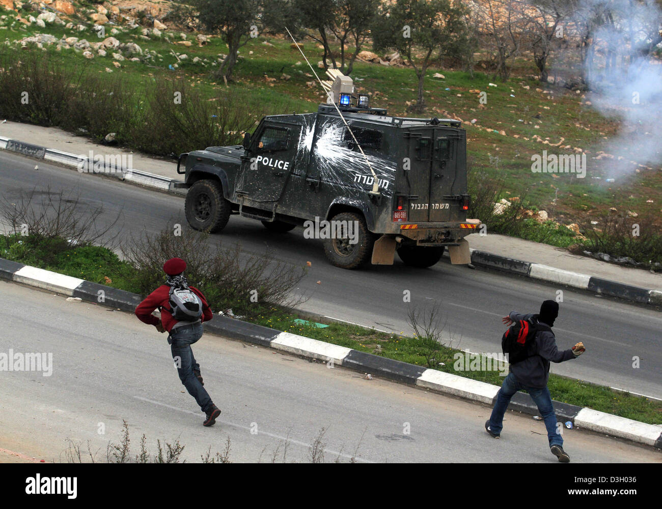 19. Februar 2013 - Ramallah, Westjordanland, Palästina - palästinensische Demonstranten mit Steinen werfen auf israelische Soldaten bei Auseinandersetzungen außerhalb Israels Ofer Militärgefängnis nach Protest zur Unterstützung der Gefangene im Hungerstreik in israelischen Gefängnissen, in der Nähe von Ramallah am 19. Februar 2013. Rund 800 Palästinenser, die Zeit in israelischen Gefängnissen wurden verweigert Essen in Solidarität mit vier Mitgefangenen, die auf langfristige Hungerstreik wurden, sagten Beamte (Credit-Bild: © Issam Rimawi/APA Images/ZUMAPRESS.com) Stockfoto