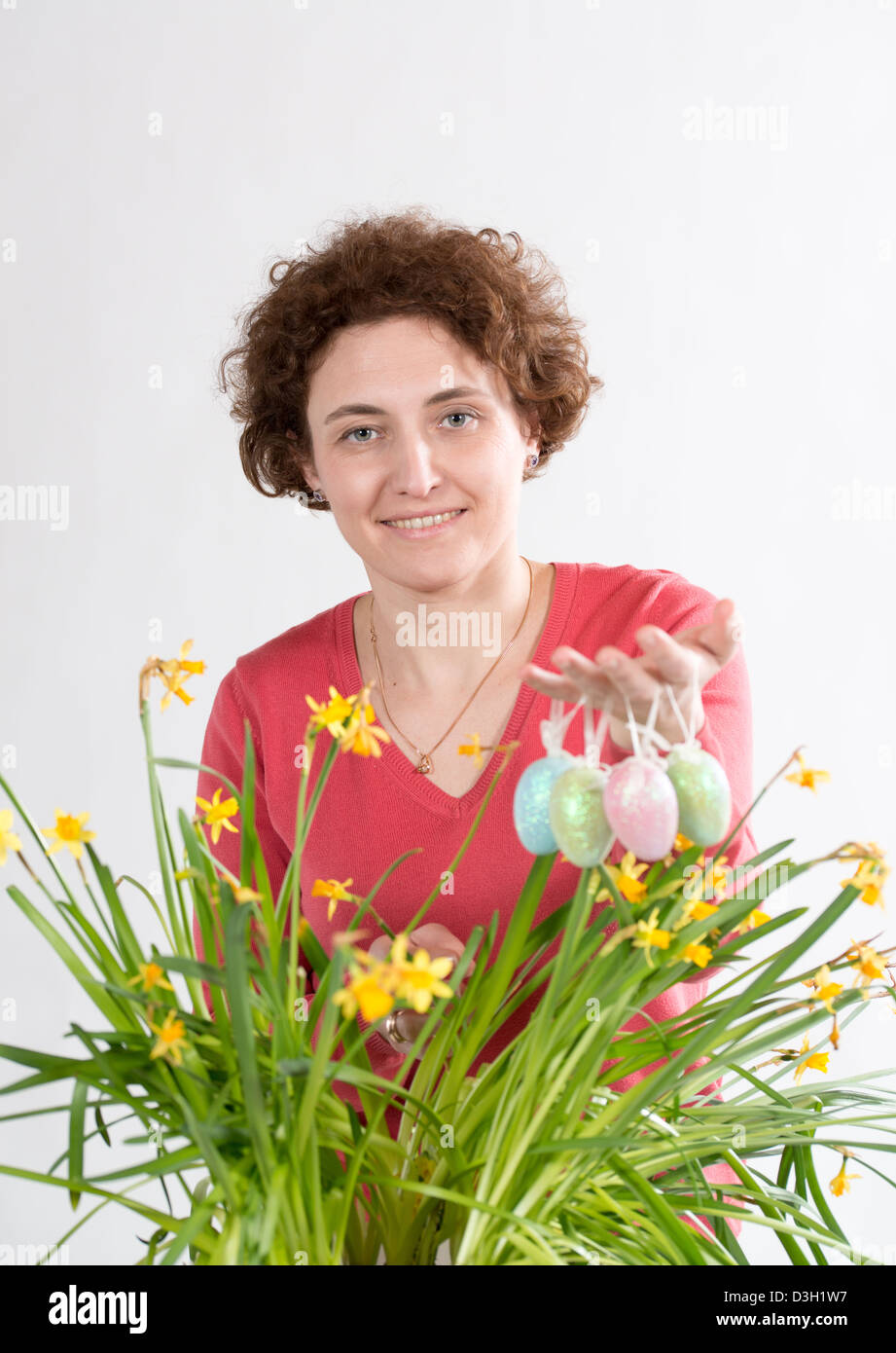 Junge lockig Frau hält, Ostereier und Eiern in gelben Narzissen aus Stockfoto