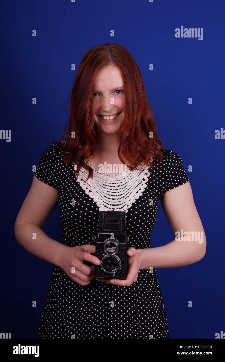 lächelnde Frau im gepunkteten Kleid mit alten TLR-Kamera Stockfoto