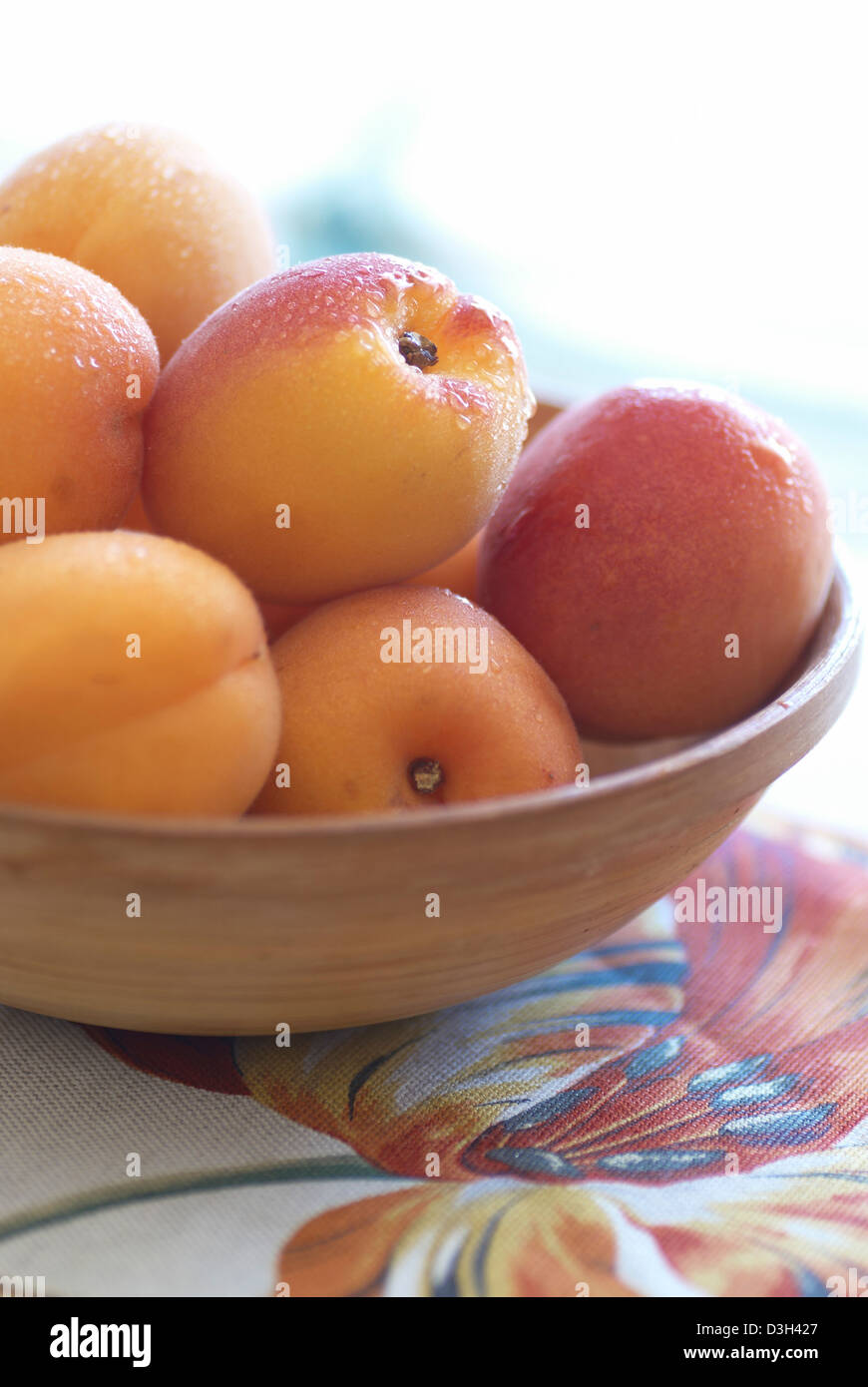 Aprikosen im Holz Schüssel auf Stoff gemalt Tulpe Stockfoto