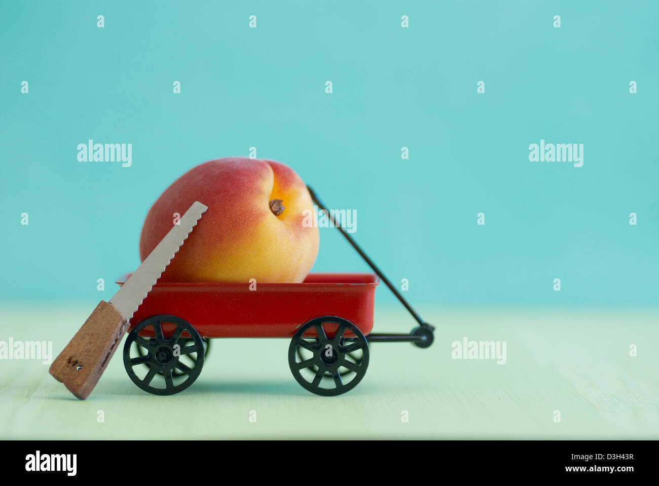 Aprikose in einem Mini-roten Wagen mit Mini Holz gesetzt sah, blauen Hintergrund Stockfoto