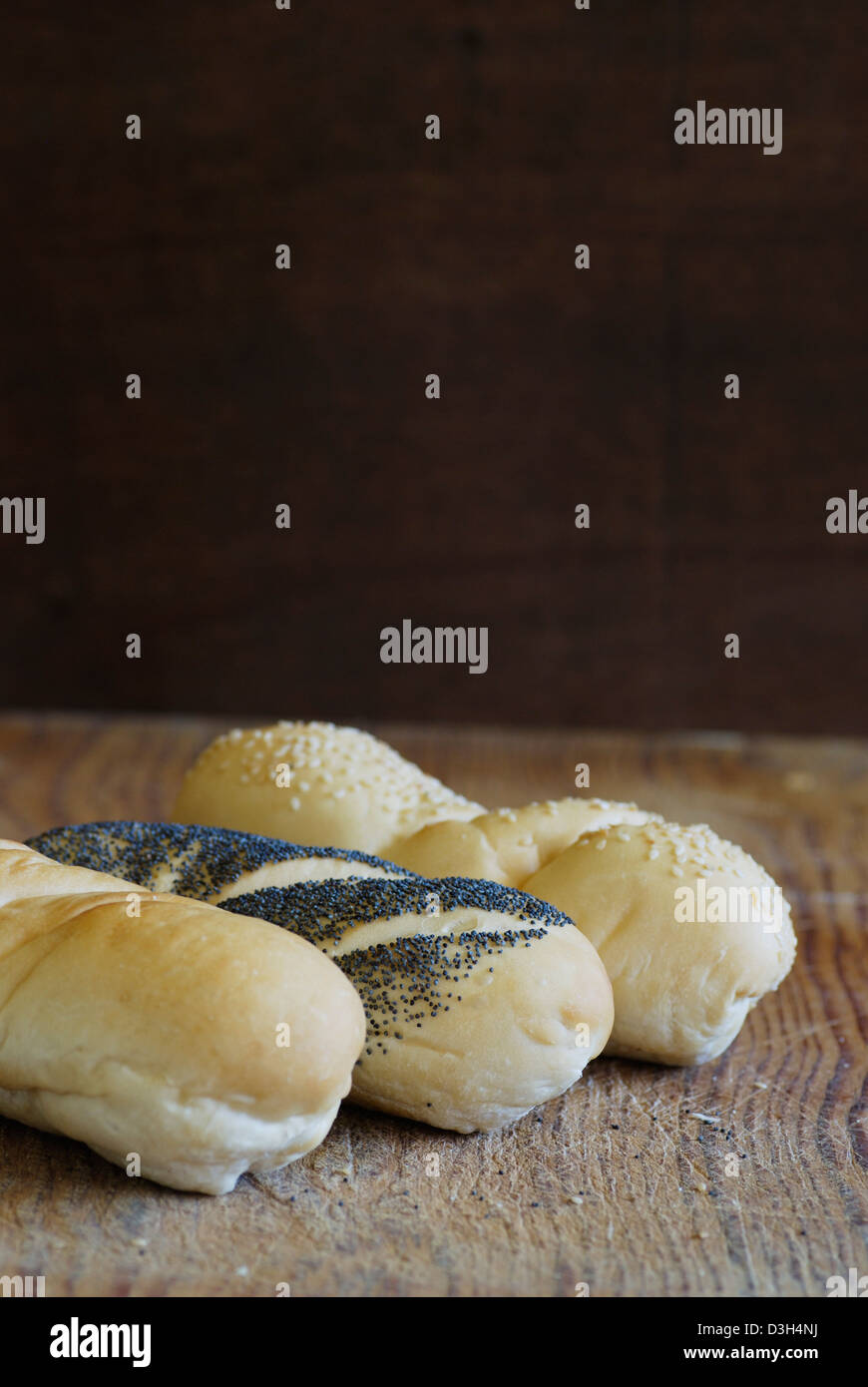 Handwerker-Sandwich Brot Brötchen, Sauerteig, Mohn, Sesam auf Holz Schneidebrett, drei Brote Stockfoto