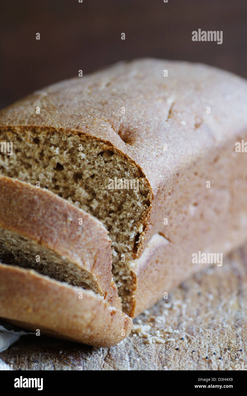 Artisan ganze Weizenbrot Brotlaib, Schneiden von Holz Brett Scheibe Brot hautnah Stockfoto