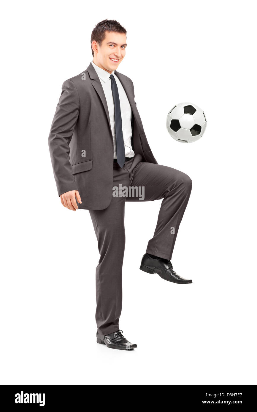 Voller Länge Porträt eines jungen hübschen Geschäftsmann treten einen Fußball isoliert auf weißem Hintergrund Stockfoto