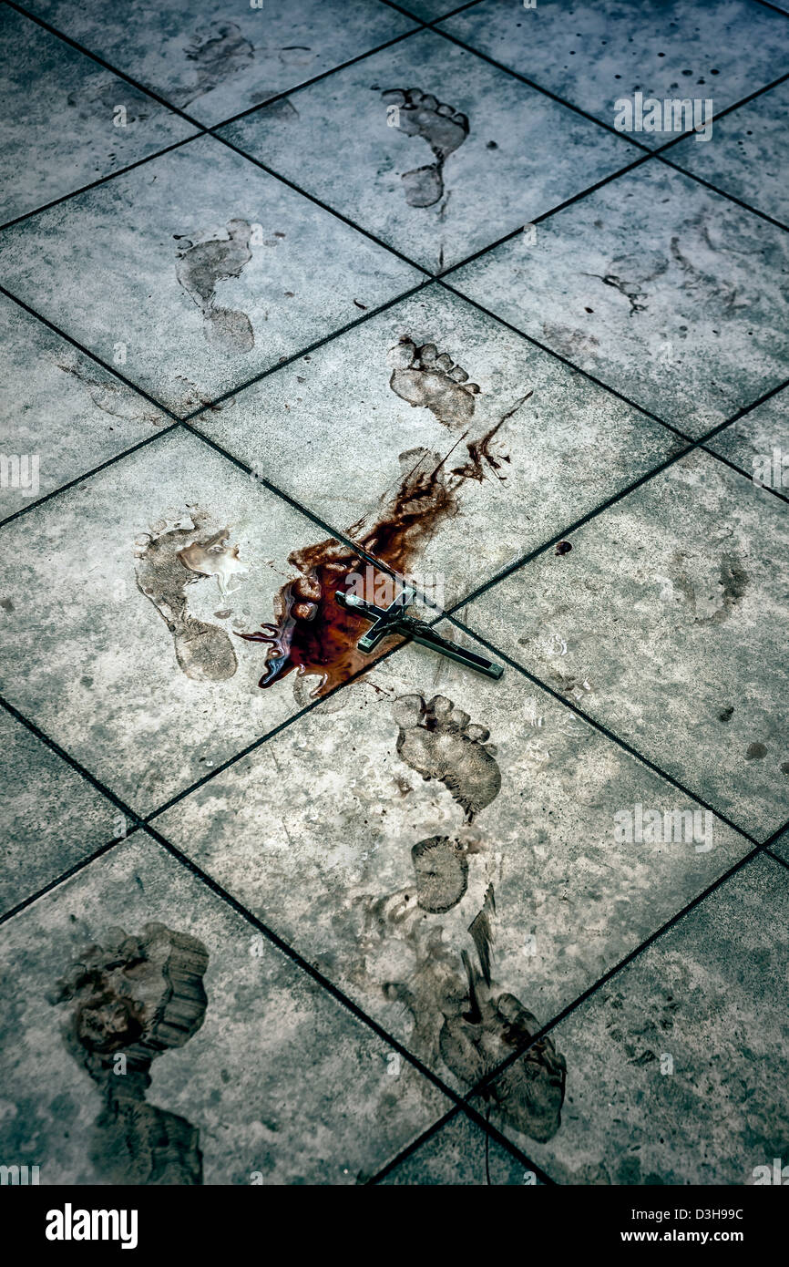 blutigen Fußspuren und ein Kruzifix in einer Blutlache auf einem Fußboden im Bad Stockfoto