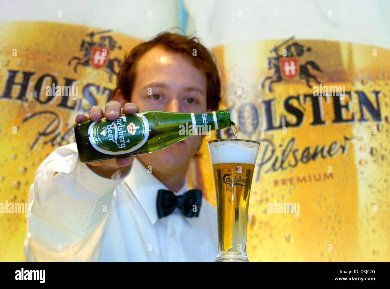 (Dpa) - ein Kellner schenkt ein Glas Carlsberg Bier steht er vor einem Werbeplakat der Holsten Brauerei in Hamburg, Deutschland, 20. Januar 2004. Carlsberg übernimmt und Deutschlands zweitgrößte Brauerei Unternehmen Holsten bricht. Nach der vereinbarten Übernahme von 51 Prozent der Aktien von Holsten Carlsberg nun auf die Holsten-Bier-Marken Koenig und Licher, die Bitb verkaufen will Stockfoto