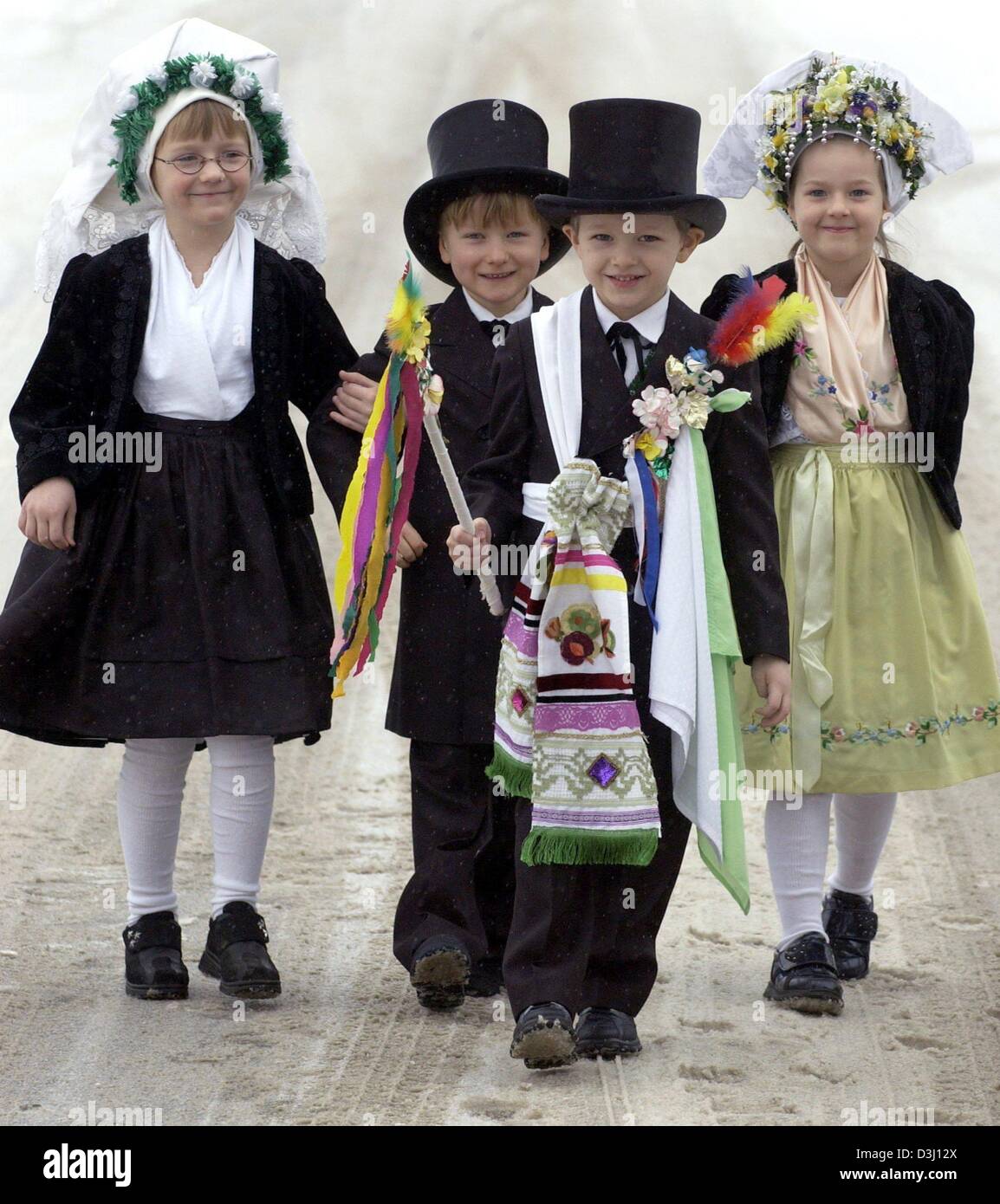 (Dpa) - das "Brautpaar" Christin (L) und William (2. v. L) sind begleitet von einladenden Simon und Brautjungfer Jasmin (R), wie alle Kinder in der traditionellen Kleidung für die Sorbisch gekleidet sind "Kinder Hochzeit" (Ptaci Kwas) in Sielow, Ostdeutschland, 29. Januar 2004. In der Vergangenheit eine offizielle Inviter (Hochzeitsbitter), gekleidet in ausgefallenen Kleidern geschmückt mit Bändern und Blumen, wo Stockfoto