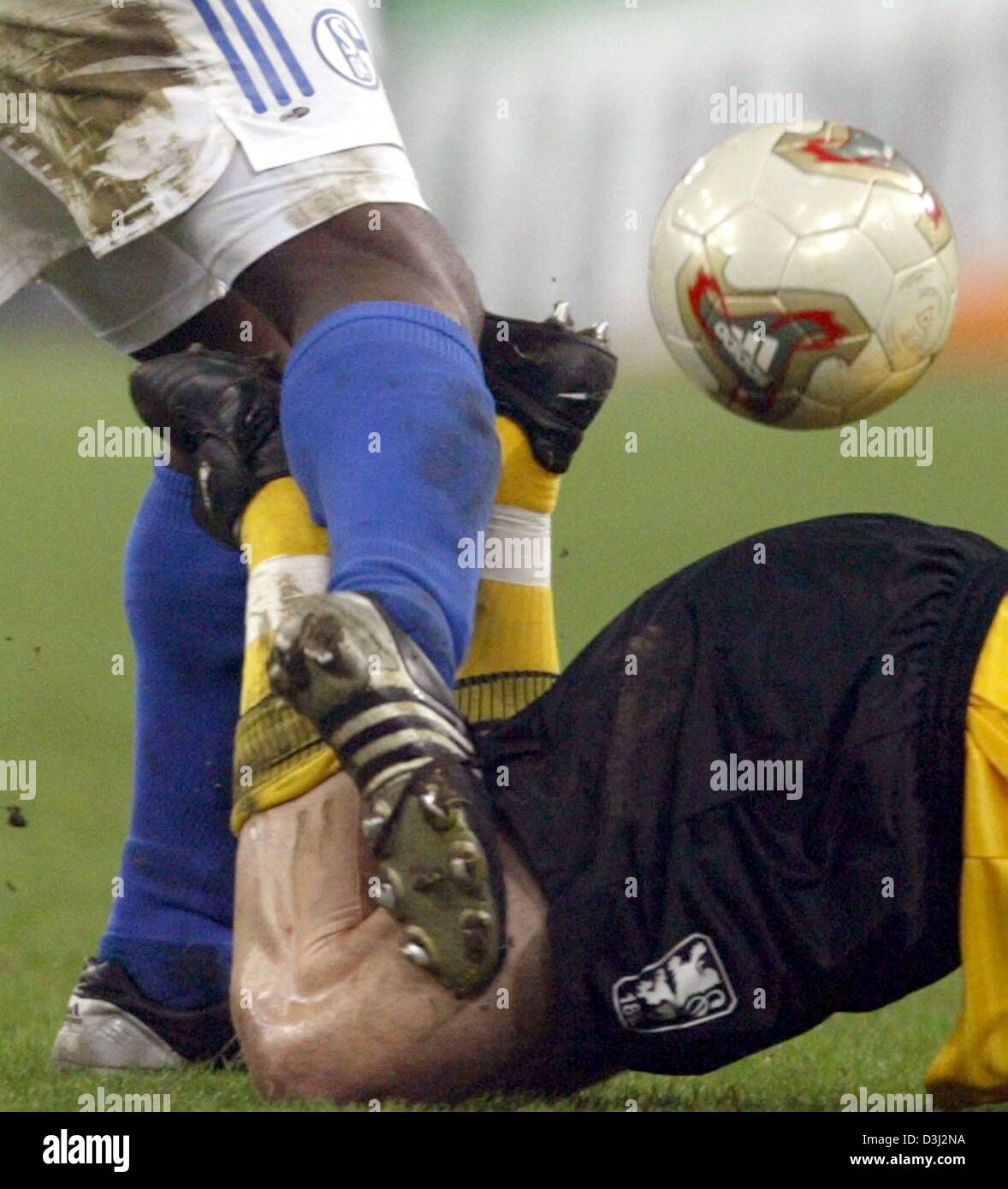 (Dpa) Zwei Fußballspieler, die Beine sehen, während eine enge Begegnung in German-Premier-League-Spiel zwischen FC Schalke 04 und TSV 1860 München am 7. Februar 2004 in Gelsenkirchen Arena "AufSchalke", das Spiel endete mit einem 0:0 Unentschieden. Stockfoto