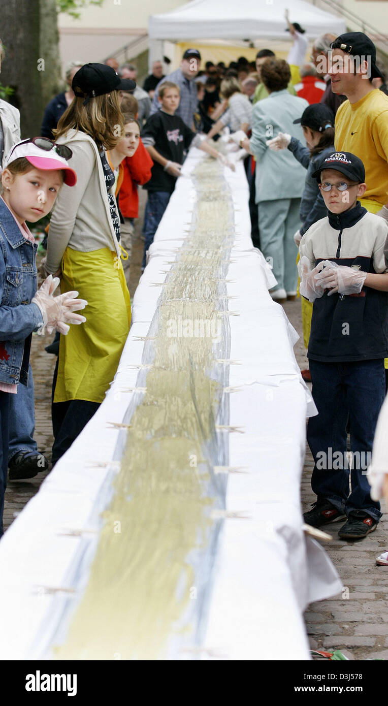 (Dpa) - Helfer stehen neben der weltweit längste Band Nudel in Mussbach, Deutschland, 16. Mai 2005. Mit seinen 128,70 Metern wird es in das Guiness Buch der Rekorde erwähnt werden. Ca. 50 kg Teig waren CompuBox, 15 Helfer beteiligt waren. Der alte Rekord wurde in New York im Jahr 2001 mit einer Länge von 127,40 Metern aufgestellt. Stockfoto